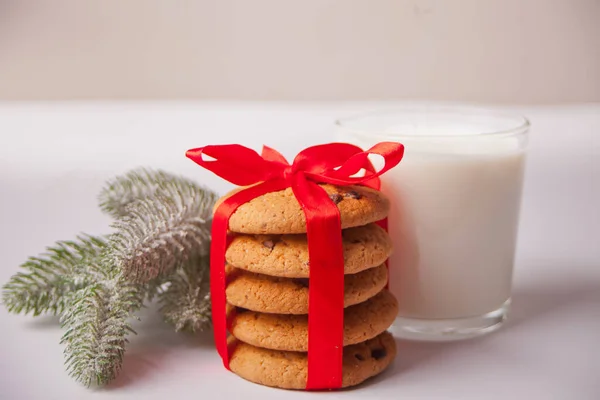 Copo de leite, biscoitos e galho de árvore de Natal na mesa branca — Fotografia de Stock