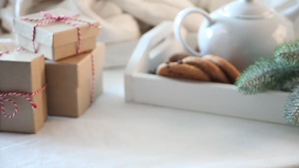 クリスマスクッキー ティーポット ギフトボックス付きの白いテーブルの上にコーヒーや紅茶の女性の手入れ — ストック動画