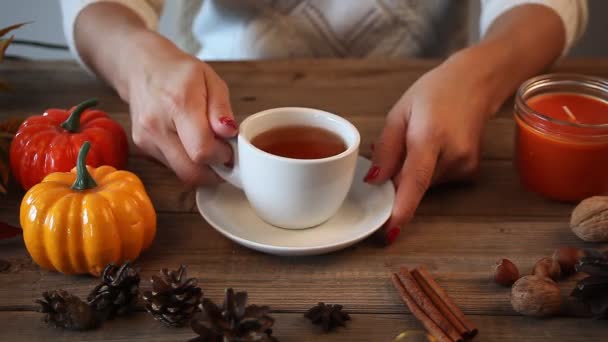 女人的手拿起并把白茶放在有南瓜 香料的旧木桌上 秋天的概念 — 图库视频影像