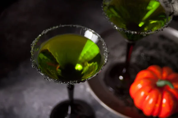 Два стакана с зеленым коктейлем для Хэллоуина на сером фоне — стоковое фото