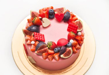 Pembe pastayı kapat. Süslü böğürtlen, meyve ve çikolata.