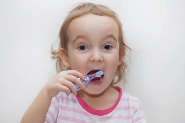 Pouco bonito menina smailing e escovar os dentes . — Fotografia de Stock