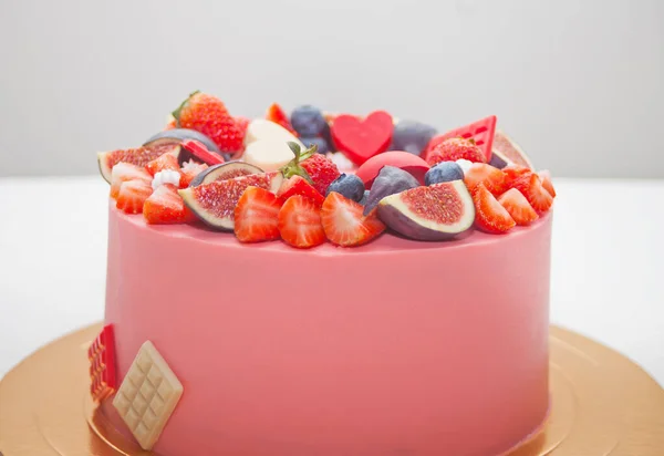 Cercano pastel rosa bayas decoradas y frutas y chocolate — Foto de Stock