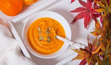 Tahta tepside beyaz bir kasede balkabağı çorbası. Sonbahar konsepti. Hasat et.