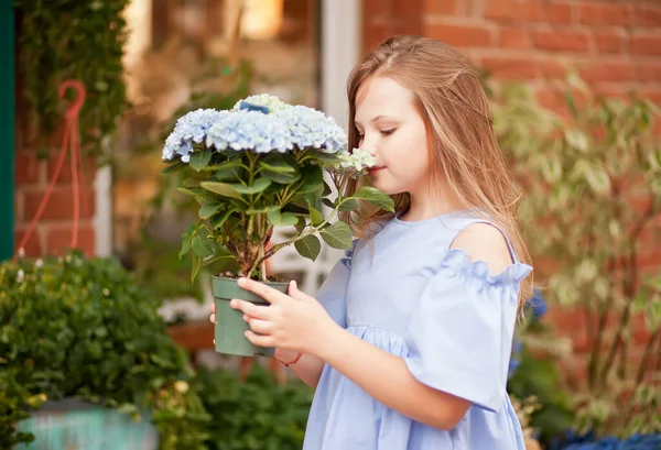 近くの花の店で青いドレスのブロンドの女の子 — ストック写真