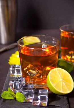 Taze Küba kokteyli ya da siyah arka planda kahverengi rom, kola, nane ve limonlu viski kola kokteyli. Long Island Buzlu Çay Kokteyli.