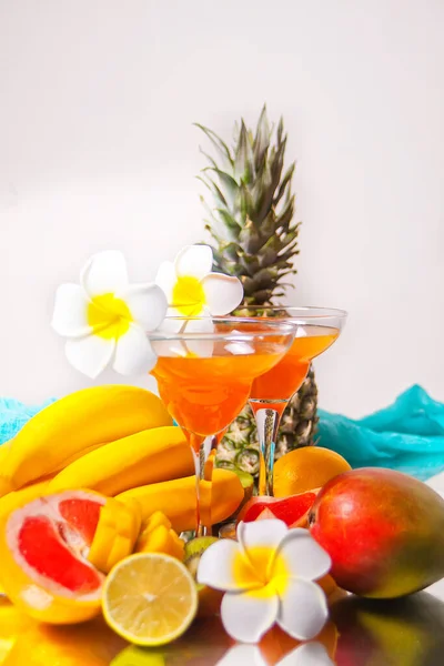 一杯热带异国情调的多果果汁鸡尾酒 背景为番石榴花和水果 — 图库照片