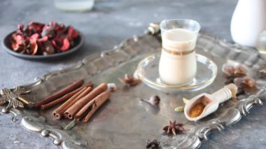 Kadın eli masaya sütlü ve baharatlı çay koydu.