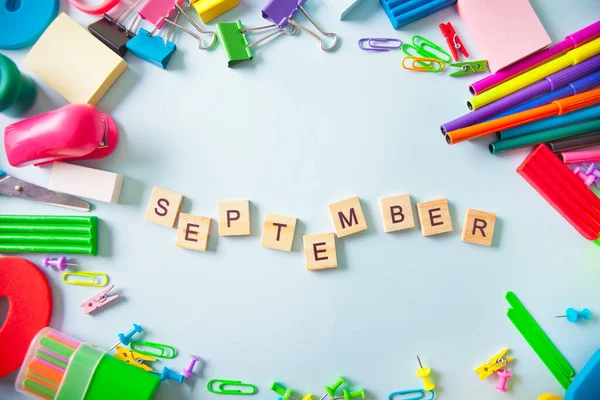 Okul malzemeleri, arka planda Eylül ayında yazılmış bir metin çerçevesi. Üst Manzara. Boşluğu kopyala.