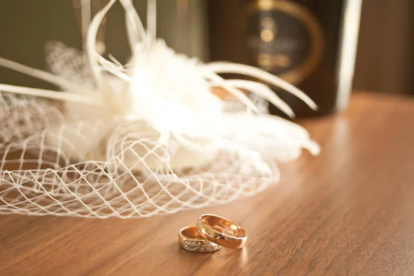 結婚指輪のシンボルの属性はシャンパンのグラスとボトルでテーブルの上にある — ストック写真