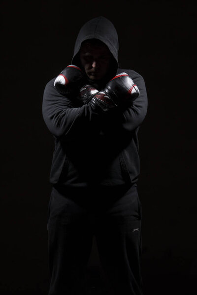 Взрослый мужчина в черной толстовке на черном фоне. Концепция изображения высокого разрешения для индустрии бокса и борьбы с ним
.