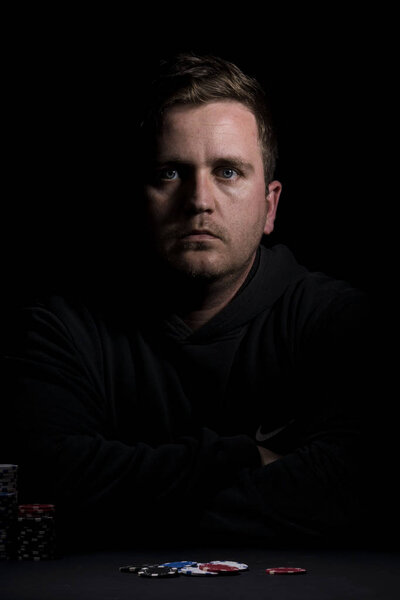 Poker table setup. High resolution image for gambling industry containning pokers chips, cards, black surface and person.