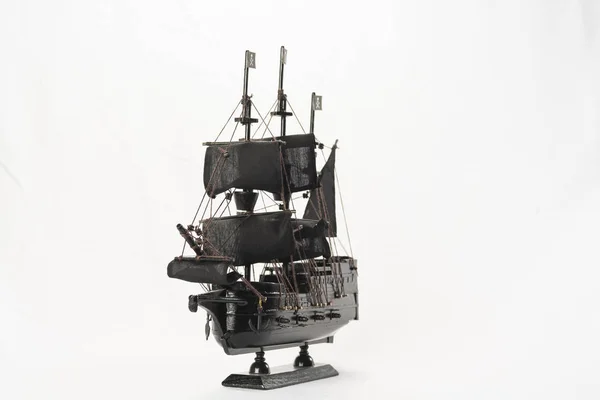Black pirate boat model on white background. High-resolution image.