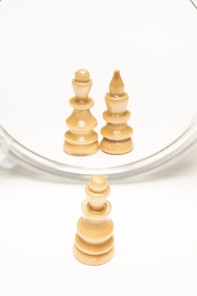 Chess pieces facing a mirror. Business and motivational concepts. High-resolution image.