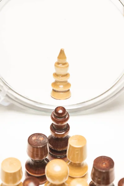 Chess pieces facing a mirror. Business and motivational concepts. High-resolution image.