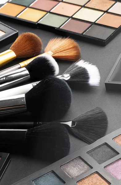 Multiple cosmetic products on black background. High resolution image for cosmetics and fashion industry.