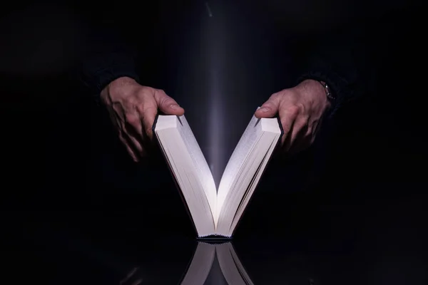 İçinden gelen parlayan ışıkla kitap okuyan kişi. Yüksek resolutin görüntü.