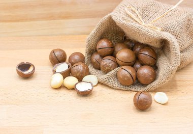 Tahta bir arka planda izole edilmiş macadamia fındıkları.