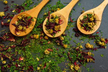 Ahşap kaşıklarda baharat arkaplanı. Maydanoz, amber, papatya