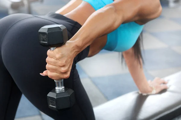 Sporty woman workout with dumbbell in gym Stock Picture