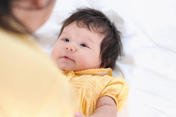 Pretty ung kvinna som innehar en nyfödd bebis i famnen. Happy familjekoncept. — Stockfoto