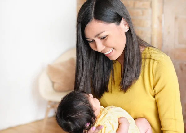 Mooie jonge vrouw die een pasgeboren baby in haar armen houdt. Gelukkig familieconcept. — Stockfoto