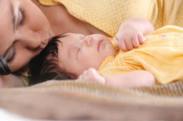 Mooie jonge vrouw die een pasgeboren baby in haar armen houdt. Gelukkig familieconcept. — Stockfoto