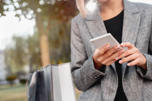 Close-up de mulher usando seu smartphone ao ar livre no parque — Fotografia de Stock