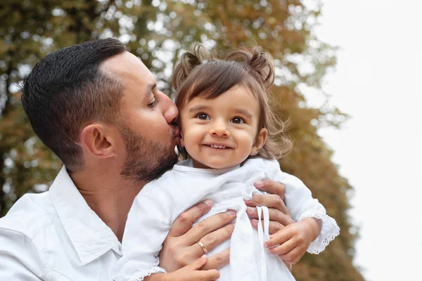 Vater küsst ihr süßes kleines Mädchen im Park — Stockfoto