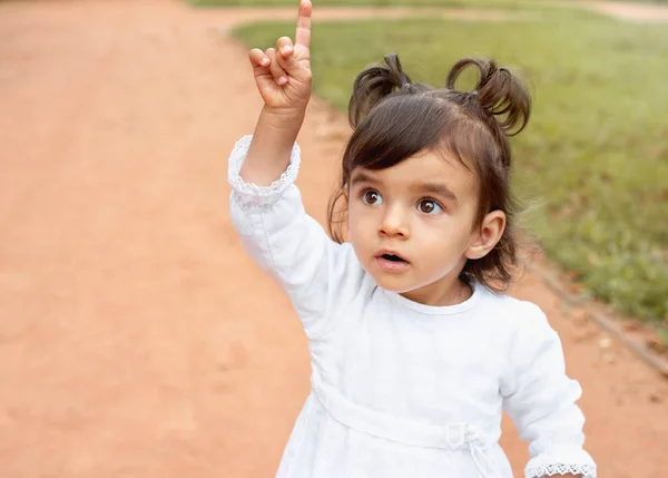 Petite fille étonnante pointant du doigt dans le parc — Photo