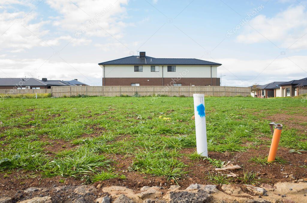 Vacant land next to some residential suburban houses. Concept of real estate development, land for sale and a new suburb, Tarneit, Melbourne, VIC Australia.