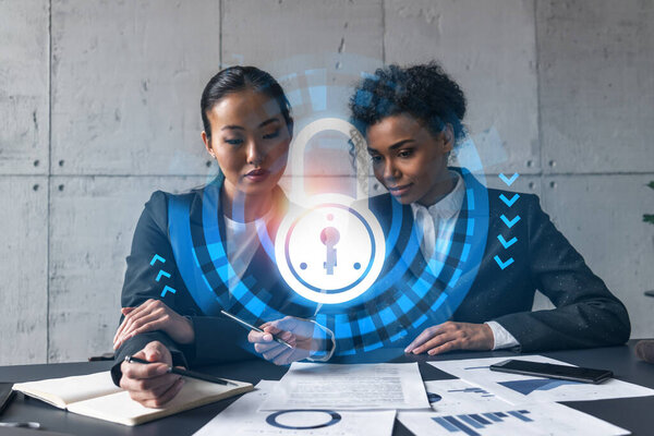 Two businesswomen work together in modern office on new project. Double exposure. Concept of success. Security lock icon.