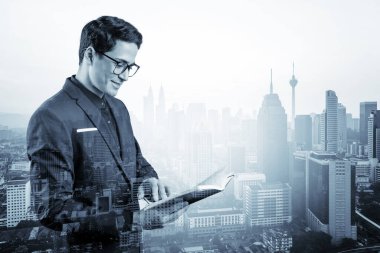 Takım elbiseli ve gözlüklü genç yakışıklı işadamı sorunla nasıl başa çıkılacağını düşünüyor, yeni kariyer fırsatları, MBA ödevi. Kuala Lumpur arka planda. Çift pozlama.