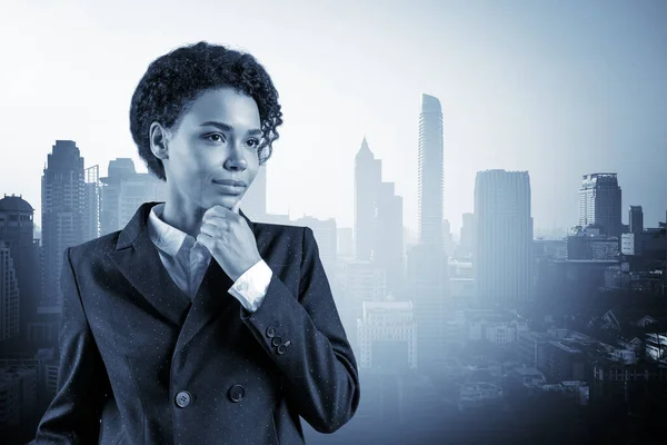 Attractive black African American business woman in suit with hand on chin thinking how to succeed, new career opportunities, MBA. Bangkok on background. Double exposure.