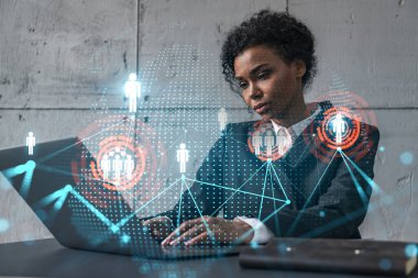 Yeni bir proje için modern ofiste dizüstü bilgisayarla yazı yazan bir iş kadını. Sosyal ağ simgesi hologram çiziyor. Çifte maruziyet. Başarı kavramı.