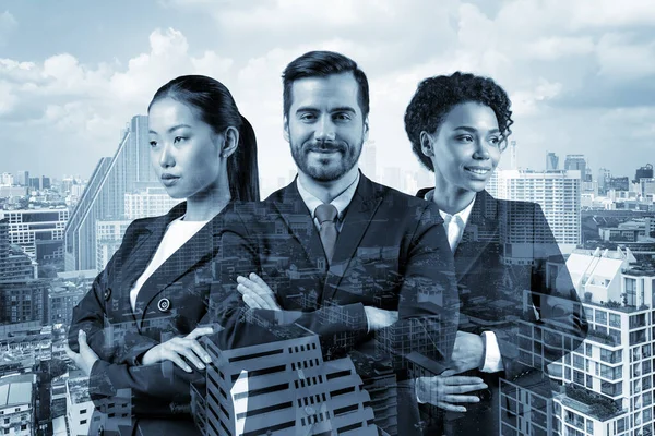 Front view of three successful smiling business consultants standing in a row in suits and crossed arms pose. Bangkok cityscape. Multinational corporate team. Double exposure.
