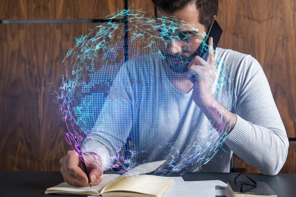 Handsome businessman in casual wears, speaking phone, taking notes at office try to solve global international issue. Double exposure. The concept of international business. Planet hologram.
