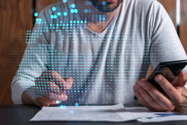 Bir adamın telefon ve dünya haritası hologramıyla kontrat imzalarken iki kez görüntülenmesi. Uluslararası iş kavramı.