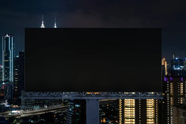Panneau d'affichage de route noir blanc avec fond de paysage urbain Kuala Lumpur la nuit. Affiche publicitaire, maquette, rendu 3D. Vue de face. Concept de marketing pour promouvoir ou vendre une idée ou un produit. — Photo