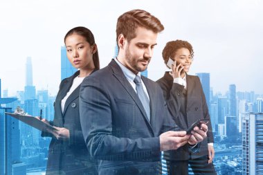 Takım elbiseli üç iş arkadaşından oluşan bir grup yeni kariyer fırsatları elde etmek için proje üzerinde birlikte çalışıyorlar. Çok uluslu şirket takımı kavramı. Kuala Lumpur. Çift pozlama.