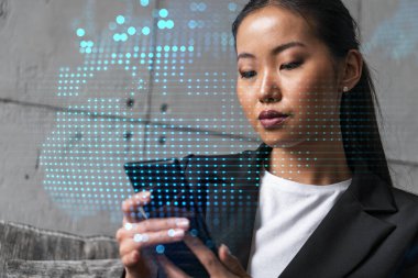 İş kadını telefonu kullanıyor, modern ofiste yeni bir proje üzerinde çalışıyor. Çifte maruziyet. Başarı kavramı. Dünya haritası Dünya hologramı.