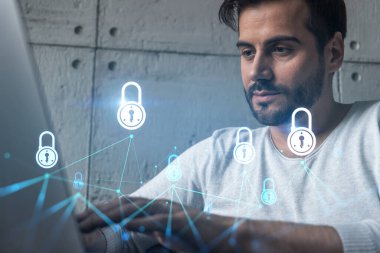 Ciddi bir Kafkasyalı programcı, verileri korumak için yeni bir güvenlik sistemi geliştirmek için dizüstü bilgisayar kullanıyor. Çifte maruziyet. IT hologram simgesini kilitle.