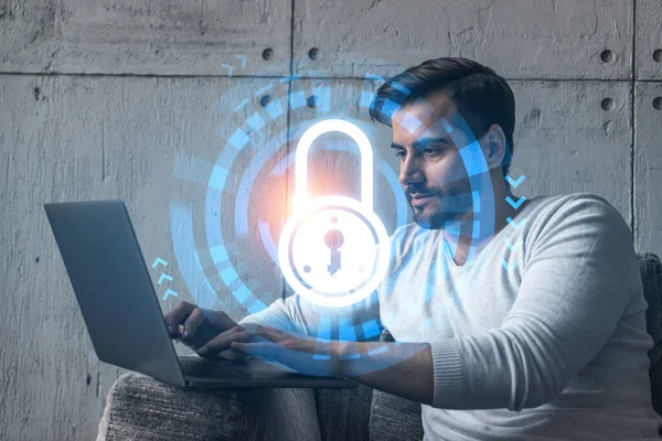 Ciddi bir Kafkasyalı programcı, verileri korumak için yeni bir güvenlik sistemi geliştirmek için dizüstü bilgisayar kullanıyor. Çifte maruziyet. IT hologram simgesini kilitle.