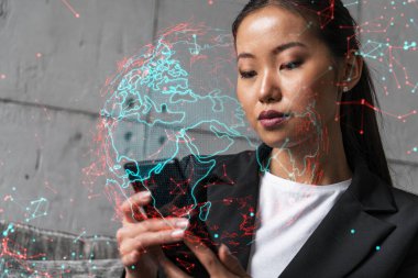 İş kadını telefonu kullanıyor, modern ofiste yeni bir proje üzerinde çalışıyor. Çifte maruziyet. Başarı kavramı. Dünya haritası Dünya hologramı.