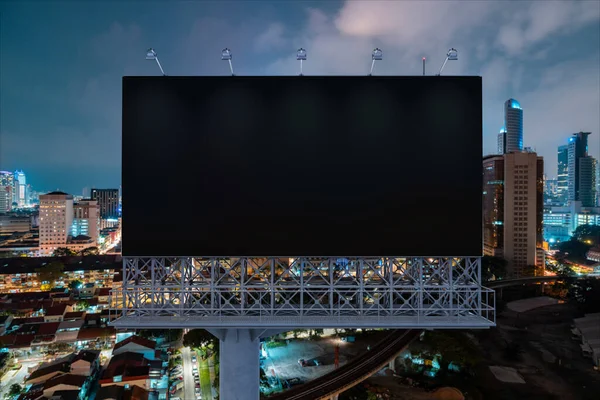 Panneau d'affichage de route noir blanc avec fond de paysage urbain Kuala Lumpur la nuit. Affiche publicitaire, maquette, rendu 3D. Vue de face. Concept de marketing pour promouvoir ou vendre une idée ou un produit. — Photo