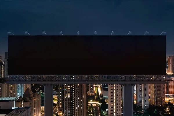 Panneau d'affichage de route noir blanc avec fond de paysage urbain Kuala Lumpur la nuit. Affiche publicitaire, maquette, rendu 3D. Vue de face. Concept de marketing pour promouvoir ou vendre une idée ou un produit. — Photo