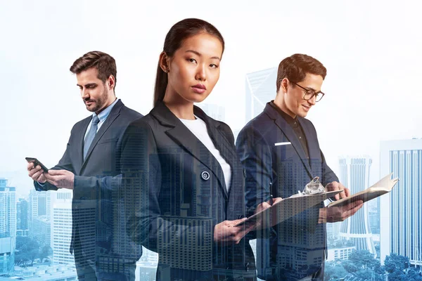 Takım elbiseli üç iş arkadaşından oluşan bir grup yeni kariyer fırsatları elde etmek için proje üzerinde birlikte çalışıyorlar. Çok uluslu şirket takımı kavramı. Kuala Lumpur. Çift pozlama.