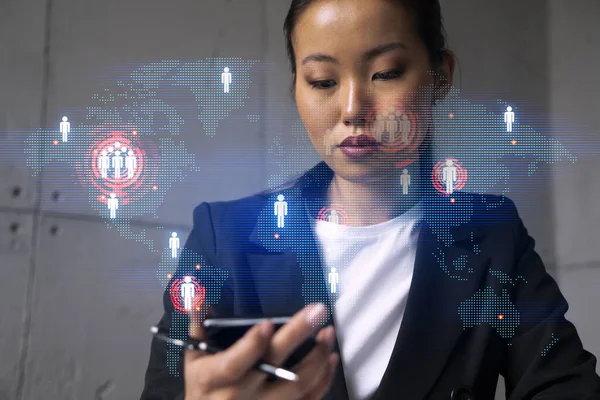 İş kadını telefonu kullanıyor, modern ofiste yeni bir proje üzerinde çalışıyor. Çifte maruziyet. Başarı kavramı. Dünya haritası Dünya hologramı.