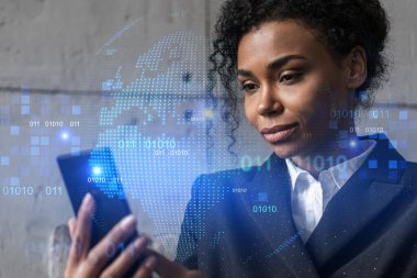 İş kadını telefonu kullanıyor, modern ofiste yeni bir proje üzerinde çalışıyor. Çifte maruziyet. Başarı kavramı. Dünya haritası Dünya hologramı.