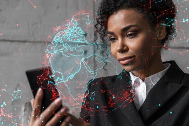 İş kadını telefonu kullanıyor, modern ofiste yeni bir proje üzerinde çalışıyor. Çifte maruziyet. Başarı kavramı. Dünya haritası Dünya hologramı.